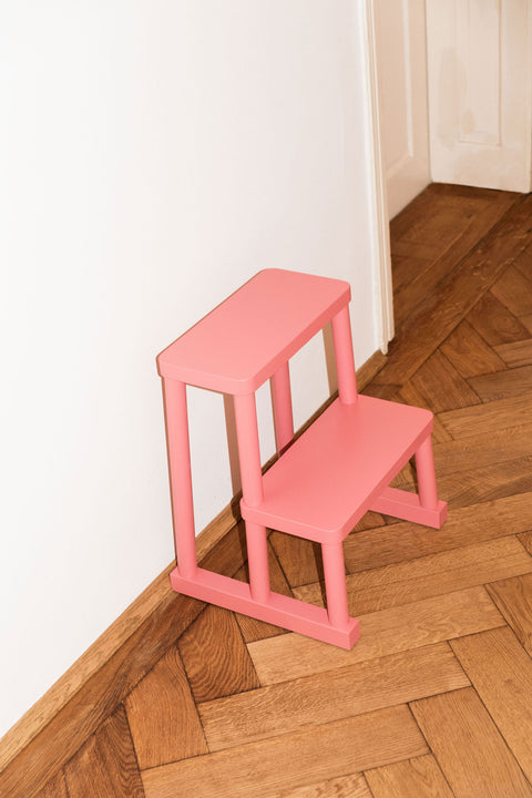 Tritthocker Adhoc in rosa auf altem Eichenparkett
