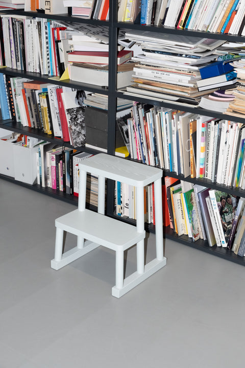 Design Tritthocker Adhoc von Edition33 in grau vor einem Bücherregal von Hay